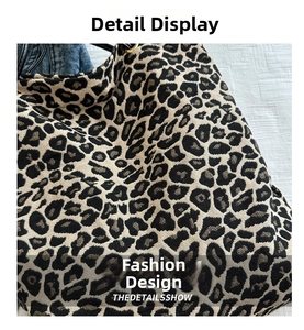 Close-up of leopard print canvas fabric and black leather strap on a large tote bag