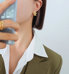 Close-up of 18k gold plated stainless steel petal earrings on model in green blazer
