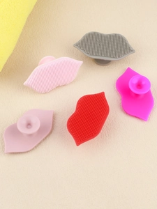Silicone lip cleaning brushes with suction handles in five various colors on a soft background