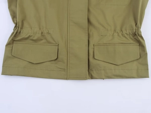 Détail d'une parka vert militaire avec de grandes poches à rabat et patte de boutonnage