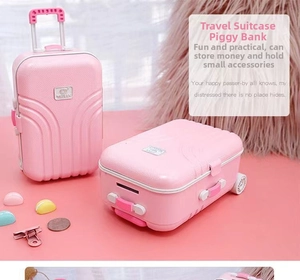 Detail of pink suitcase piggy bank with retractable handle and textured surface