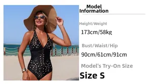 Detail of black one-piece swimsuit featuring laser-cut floral patterns and halter neck design