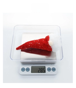 Close-up of a festive gnome hat showing a lightweight 28.5g measurement on a scale