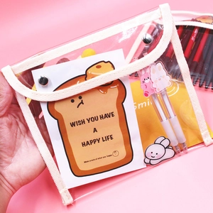 Close-up of clear PVC stationery bag with metal buckle and cute cartoon accessories