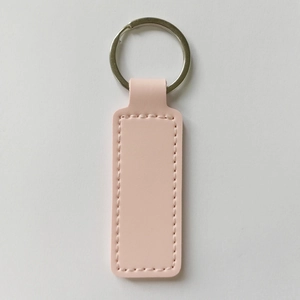 Detail of pink PU leather keychain with double-sided stitching and silver metal ring