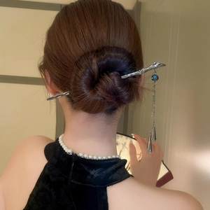 Silver branch hair pin with blue beads and long tassels worn in an elegant updo