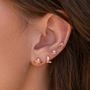Close-up of western cowboy style rose gold studs with sheriff star and opal stones