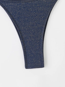 Gros plan du tissu de bikini bleu marine à volants avec paillettes dorées brillantes