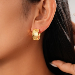 Close-up of 18K gold plated hoop earring with textured concave ripples on model