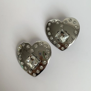 Detail shot of heart-shaped earrings with square center stone and small rhinestones