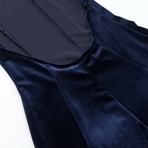 Detail of the stitching and navy velvet fabric texture of the backless halter maxi dress