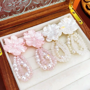 Detailed macro view of vintage floral pearl drop earrings in pink and white hues