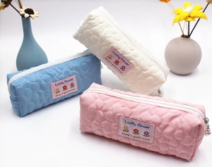 Detail of quilted floral stationery bags with pearl zipper charms in three colors