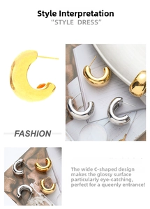 Close-up of chunky C-shape hoop earrings in polished gold and silver finish