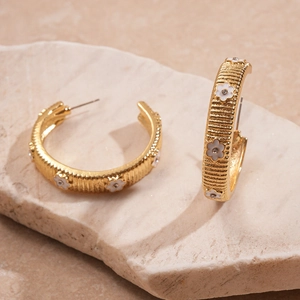 Gold C-shaped textured earrings with white enamel flowers and clear crystal accents