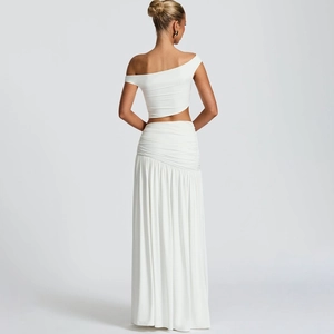 Back view of elegant white two-piece set featuring asymmetric crop top and ruched skirt