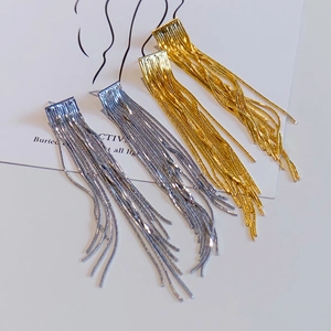 Detail der eleganten langen Quastenkette-Ohrhänger in Gold und Silber auf Display