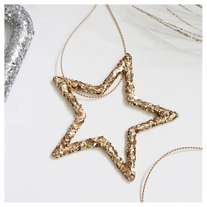 Macro shot of gold sequin star ornament with glitter finish and metallic hanging cord
