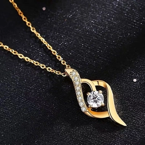 Macro view of gold-plated heart pendant with sparkling round center stone and pavé detail