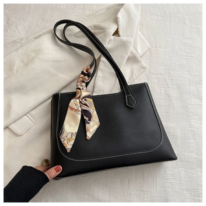 Détail du sac cabas en cuir noir avec surpiqûres blanches et accessoire foulard en soie imprimé