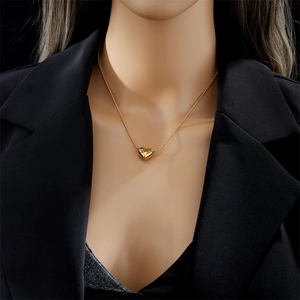 Golden beaded necklace with 3D heart pendant and colorful gems on a female model