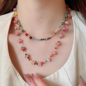 Close-up of double-layered beaded necklace with colorful crystal beads on a model