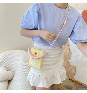 Detail of yellow puffy crossbody bag with pink rope strap and nice day embroidery