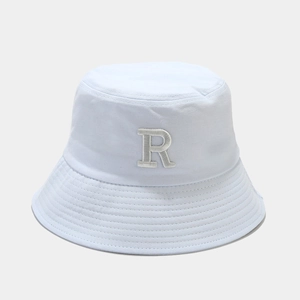 Gros plan d'un bob en coton bleu clair avec une broderie 3D de la lettre R en blanc
