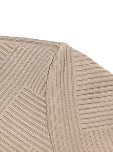 Close-up of beige knit hoodie texture showing ribbed pattern and premium shoulder stitching