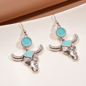 Detail view of retro silver ox head earrings with sky blue enamel and boho texture
