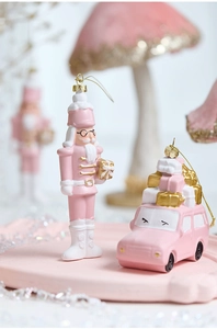 Detail of pink nutcracker and car ornaments with matte finish and gold accents