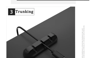 Close-up of a black 3-slot cable organizer clip holding a wire on a grey surface