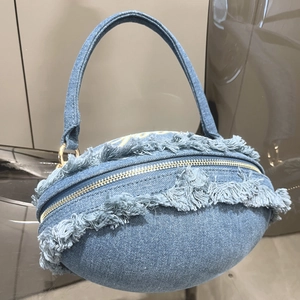 Detailed view of the blue denim rugby-shaped handbag featuring trendy frayed fringe edges