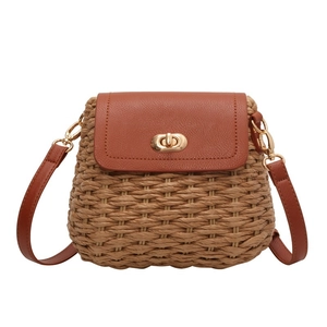 Brown handmade straw woven crossbody bag with leather flap and metal turn-lock closure