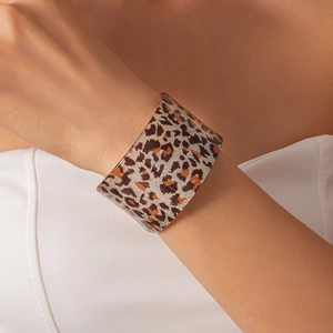 Macro shot of wide acrylic cuff bracelet with leopard print and embedded silver glitter