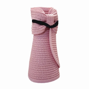 Dettaglio della visiera in paglia rosa con trama intrecciata e fiocco nero decorativo