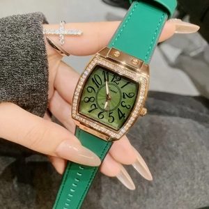 Elegant rose gold tonneau watch with green dial and leather strap worn by a model
