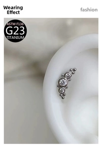 Macro view of ASTM F136 G23 Titanium ear piercing with three clear cubic zirconia stones