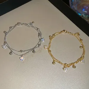 Detail of 18k gold plated double-layer chain bracelets with heart-shaped cubic zirconia charms