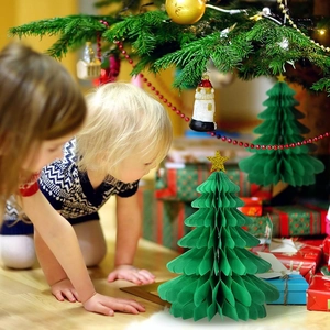 Détail des sapins de Noël en papier alvéolé vert avec des enfants jouant dans un décor festif