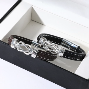 Macro shot of black and brown braided leather bracelets with magnetic clasps in a gift box