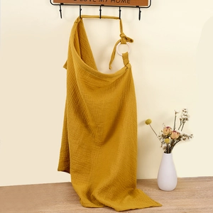 Close-up of ginger yellow cotton muslin nursing cover with adjustable metal rings