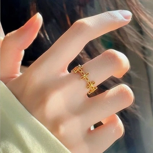 Macro detail of gold-plated hollow flower ring with elegant light and shadow on hand