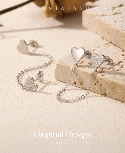 Detailed view of asymmetric S925 silver heart earrings with pavé stones and chain