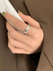 Detail view of a 925 sterling silver wavy ring worn on a finger with minimalist design