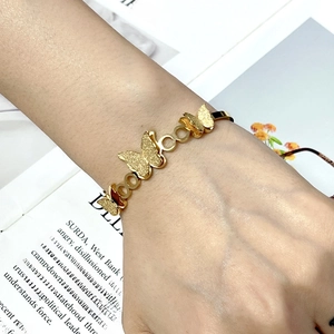 Detailed view of a gold-tone butterfly open cuff bangle featuring matte and polished finishes