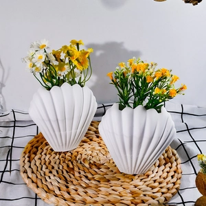 Close-up of a seashell-shaped white silicone mold used for DIY plaster flower vases