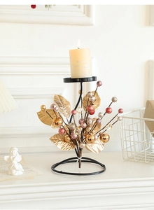 Detailed view of metal Christmas candle holder with golden leaves and red berries decor