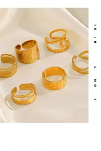 Detailed close-up of adjustable 18K gold-plated rings set on elegant beige silk fabric
