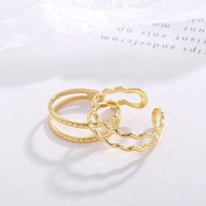 Close-up of golden double-layered leaf rings with hammered and wavy textures